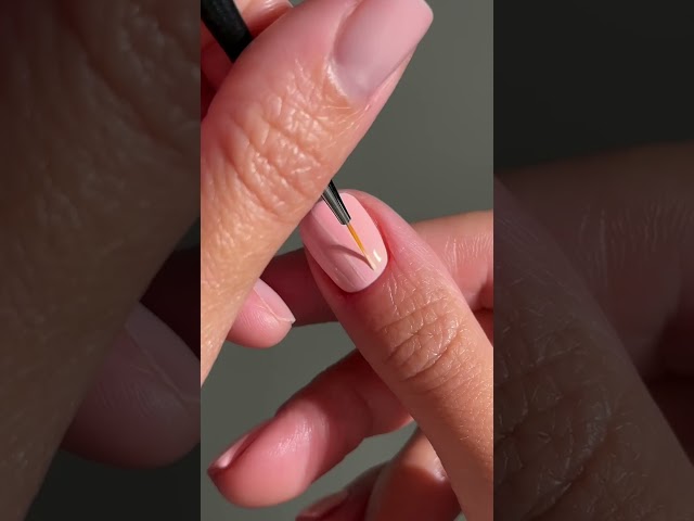 See Glossy Pink Lipstick Applied with a Dark Triangular Applicator