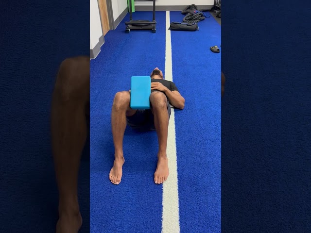 Floor lying knees up yoga block isometric squeeze drill