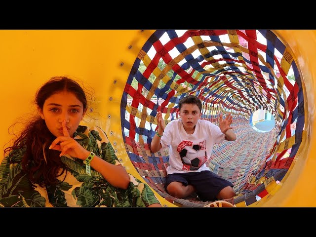 Heidi y Zidane juegan al escondite en un parque de atracciones para niños
