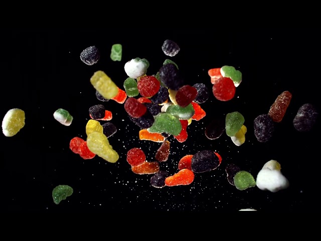 Cinematic Slow Motion Of Floating Gummy Candies And Sugar Particles