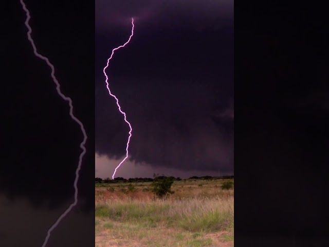 Absolutely gargantuan double lightning strike from a powerful supercell (wall cloud in the BG!!)